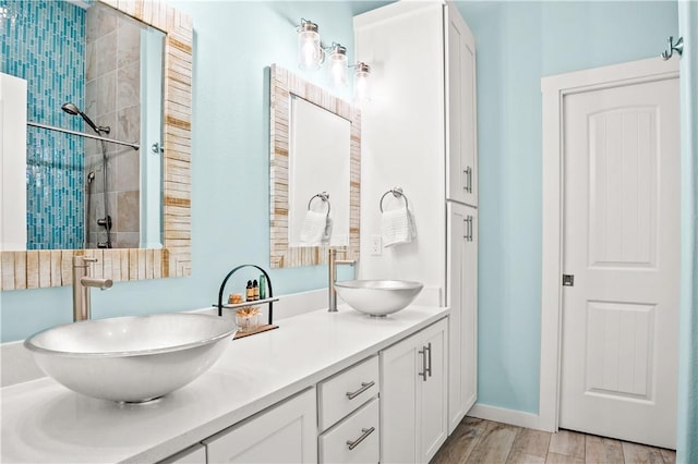 bathroom with vanity, hardwood / wood-style floors, and a tile shower