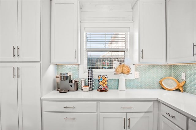 kitchen featuring tasteful backsplash and white cabinets