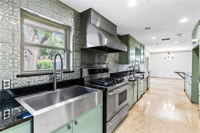 kitchen featuring sink, stainless steel range with gas cooktop, green cabinets, and wall chimney range hood