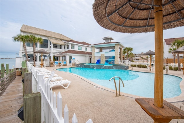 view of pool with a gazebo, a water view, pool water feature, and a patio area