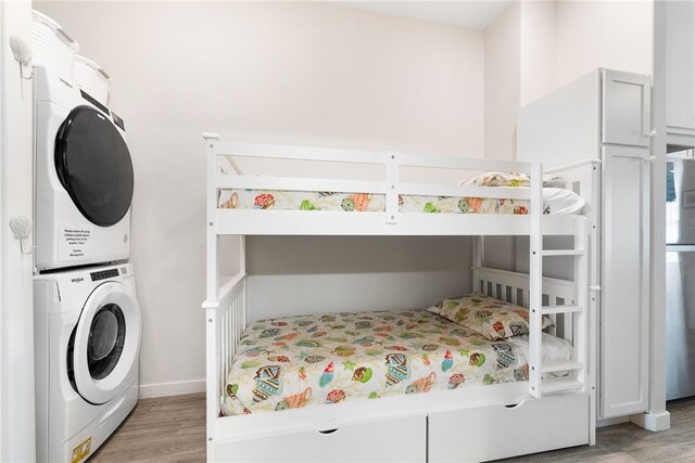 bedroom featuring light hardwood / wood-style floors and stacked washer / drying machine