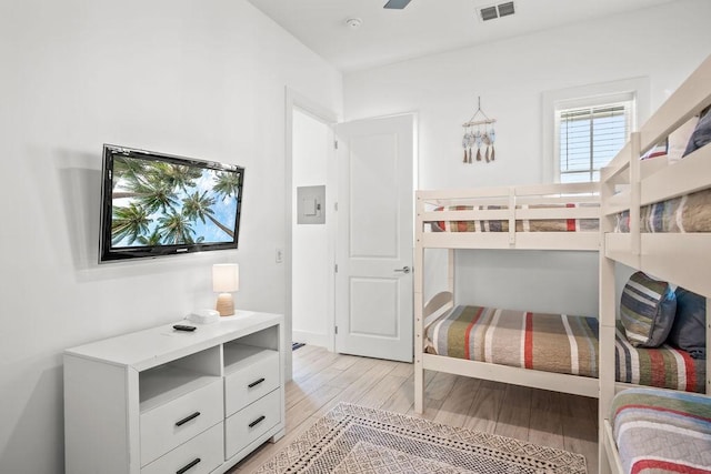 bedroom with light wood-style floors and visible vents