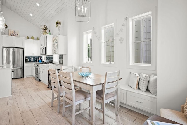 dining area with a notable chandelier, recessed lighting, wood tiled floor, high vaulted ceiling, and wooden ceiling