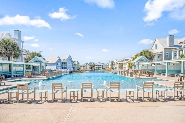 community pool with a residential view and a patio area