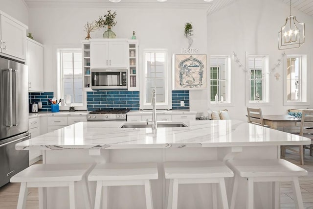 kitchen featuring stainless steel appliances, tasteful backsplash, a breakfast bar area, and a sink