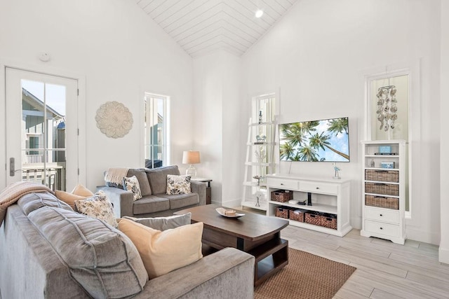 living area featuring high vaulted ceiling and light wood-style flooring