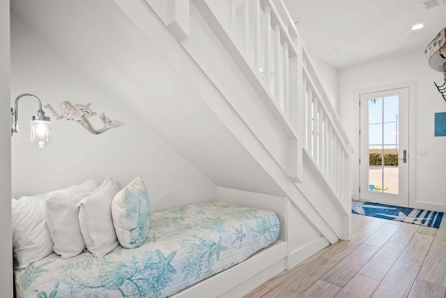 bedroom with access to outside, wood tiled floor, baseboards, and visible vents