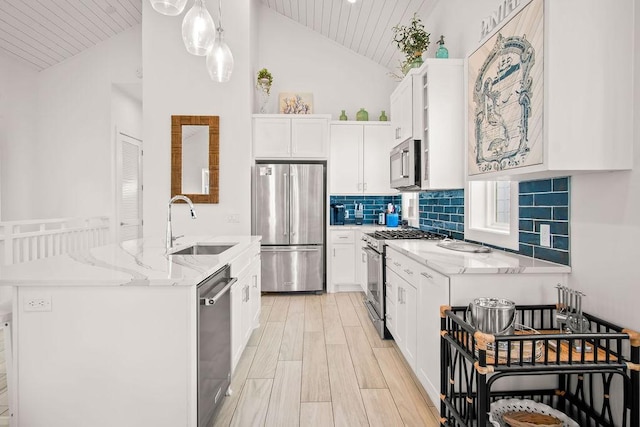 kitchen with stainless steel appliances, wood finish floors, white cabinets, and a center island with sink