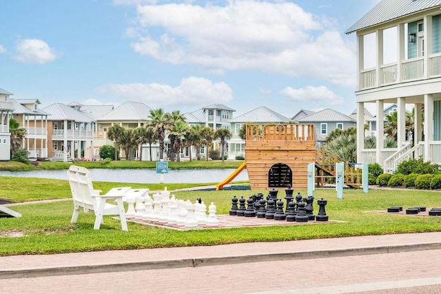 community jungle gym featuring a water view and a yard