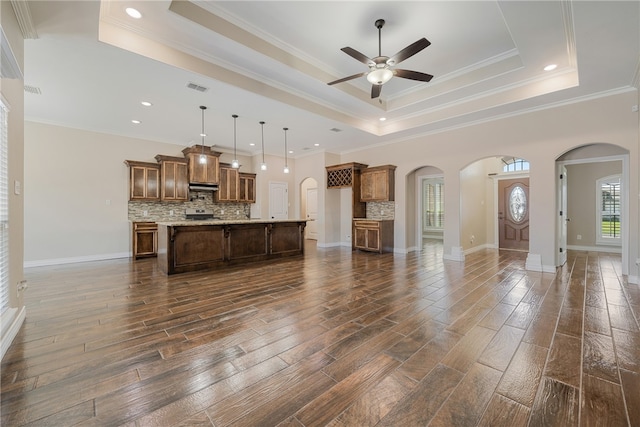 living room with dark hardwood / wood-style flooring, crown molding, and a tray ceiling