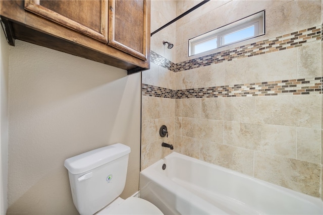 bathroom with tiled shower / bath combo and toilet