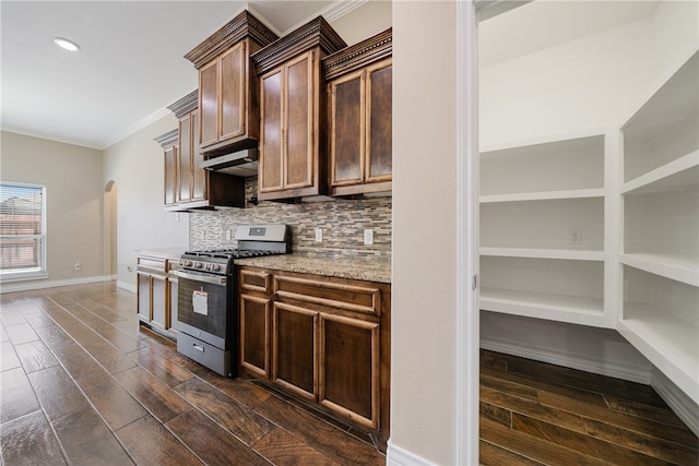 kitchen featuring light stone counters, crown molding, backsplash, stainless steel gas range oven, and dark hardwood / wood-style flooring