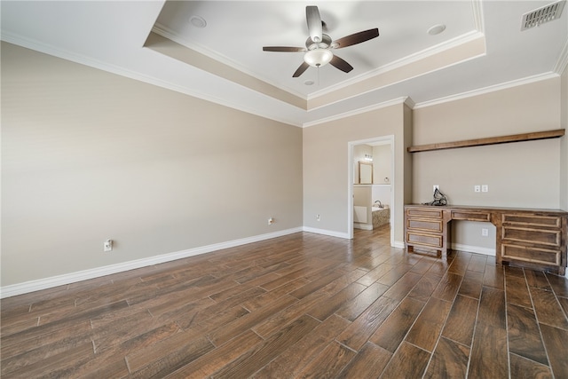 unfurnished living room featuring ornamental molding, built in desk, dark hardwood / wood-style floors, and a raised ceiling