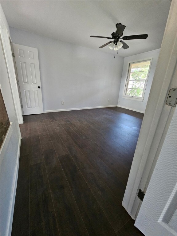 2802 Devon Dr, Corpus Christi, TX 78404 - empty room with dark wood finished floors and a ceiling fan