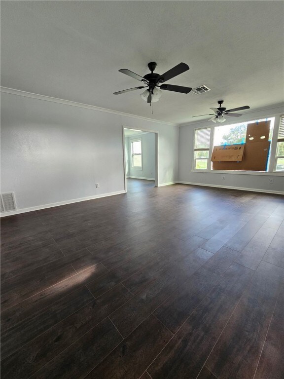 2802 Devon Dr, Corpus Christi, TX 78404 - unfurnished room featuring dark wood finished floors, ornamental molding, and a ceiling fan