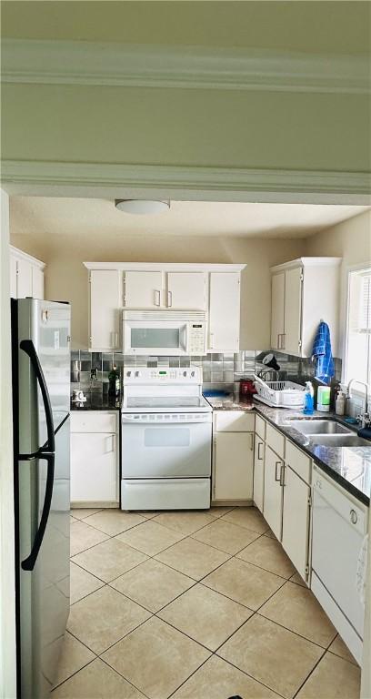 kitchen featuring backsplash, white appliances, light tile patterned flooring, white cabinets, and sink