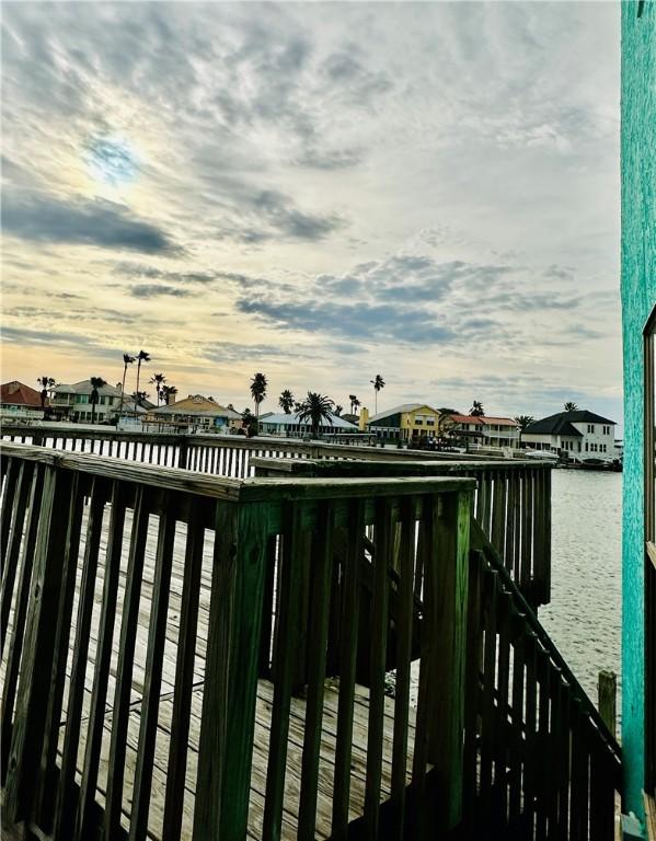 gate at dusk featuring a water view