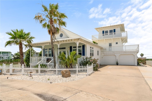 4820 Sanibel Ln, Port Aransas, TX 78373 - view of front of house with a garage, a fenced front yard, a balcony, covered porch, and driveway