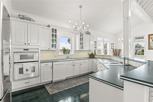 4820 Sanibel Ln, Port Aransas, TX 78373 - kitchen featuring tasteful backsplash, a sink, dark countertops, white appliances, and a notable chandelier
