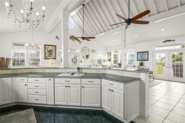 4820 Sanibel Ln, Port Aransas, TX 78373 - kitchen featuring white cabinetry, beamed ceiling, dark countertops, open floor plan, and ceiling fan with notable chandelier