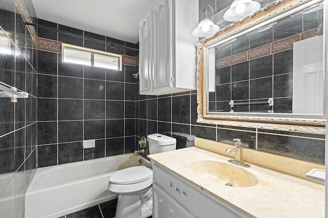bathroom featuring vanity, toilet, tile walls, shower / washtub combination, and tasteful backsplash