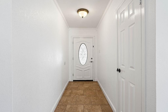 doorway featuring baseboards, ornamental molding, and stone tile floors
