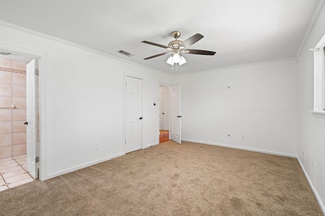 unfurnished bedroom with carpet flooring, crown molding, visible vents, and baseboards