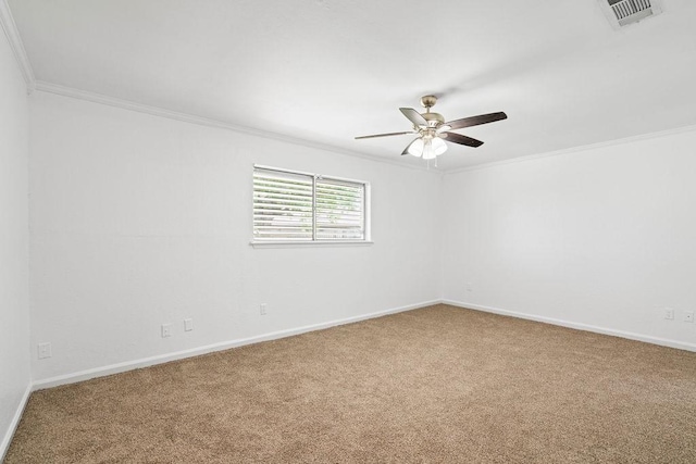 empty room featuring crown molding, carpet flooring, a ceiling fan, baseboards, and visible vents