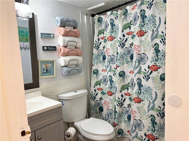 bathroom with toilet, tile walls, a textured ceiling, vanity, and a shower with shower curtain