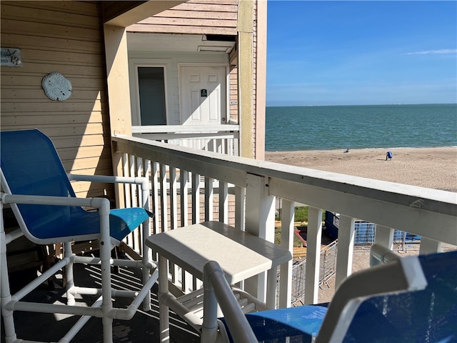 balcony with a water view and a beach view