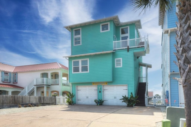 2525 S 11th St Unit 66, Port Aransas, TX 78373 - view of front facade featuring a balcony, an attached garage, concrete driveway, and stairway
