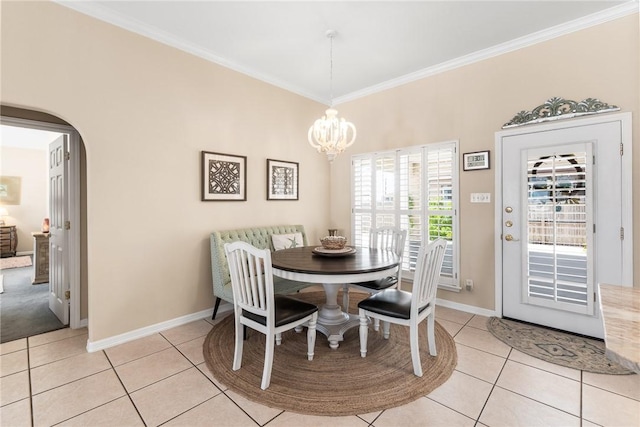 dining area with light tile patterned floors, crown molding, a chandelier, baseboards, and arched walkways