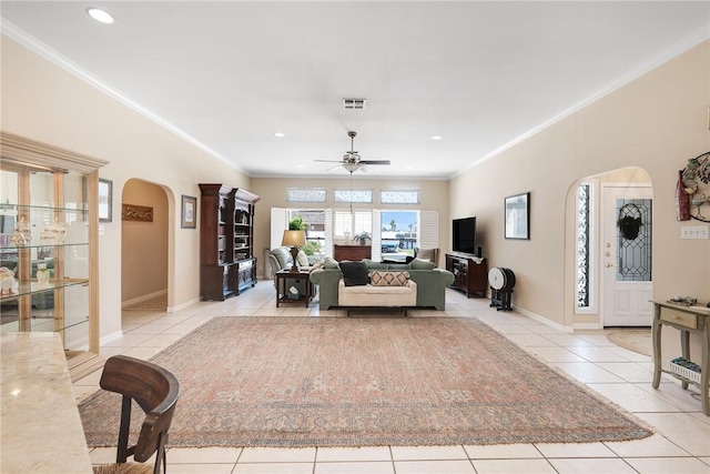 living room with arched walkways, light tile patterned flooring, a ceiling fan, ornamental molding, and recessed lighting