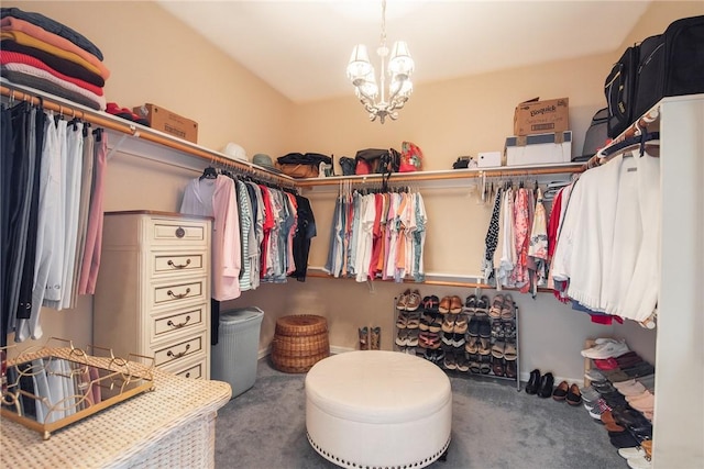 walk in closet with carpet floors and a chandelier