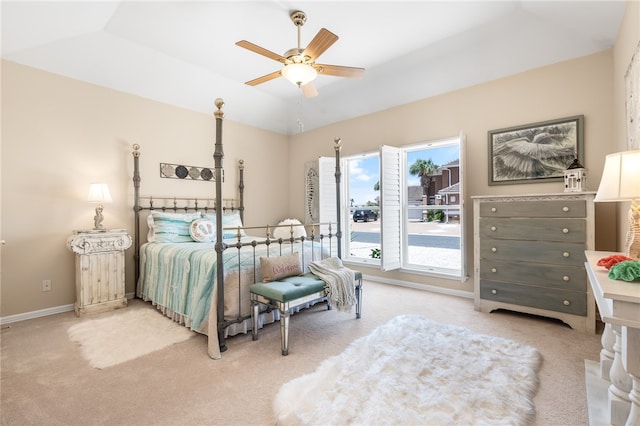 carpeted bedroom featuring vaulted ceiling, ceiling fan, and a raised ceiling