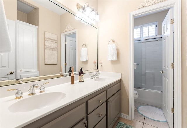 bathroom with tile patterned floors, double vanity, toilet, and shower / washtub combination