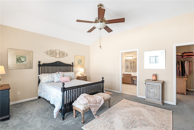 carpeted bedroom with a closet, a walk in closet, connected bathroom, lofted ceiling, and ceiling fan