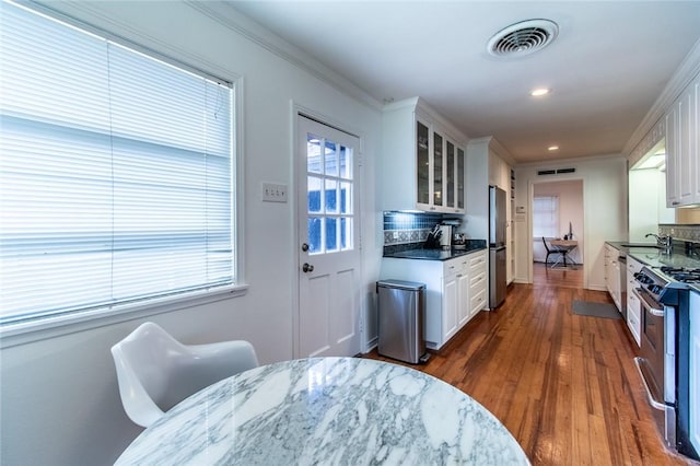 419 Peerman Pl, Corpus Christi, TX 78411 - kitchen with stainless steel appliances, tasteful backsplash, glass insert cabinets, white cabinets, and recessed lighting