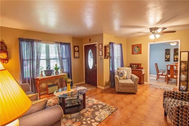 905 E Randall St, Beeville, TX 78102 - living room with light tile patterned floors, baseboards, and a ceiling fan