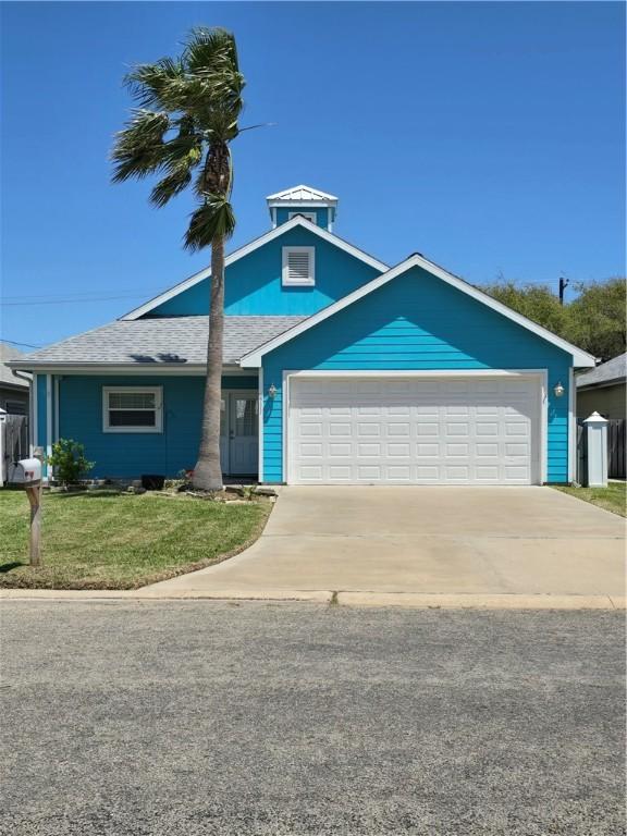 view of front of property featuring a front lawn, concrete driveway, and an attached garage
