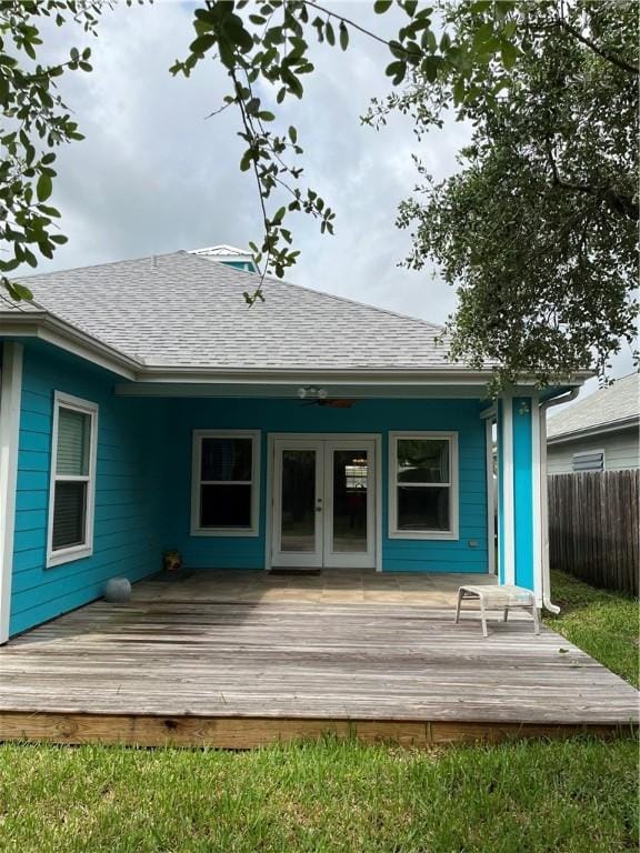 back of property featuring a deck, fence, french doors, and a shingled roof