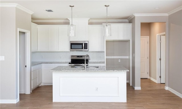 6214 Sadie St, Corpus Christi, TX 78415 - kitchen with appliances with stainless steel finishes, an island with sink, light wood finished floors, white cabinetry, and crown molding