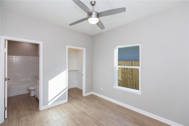 6214 Sadie St, Corpus Christi, TX 78415 - unfurnished bedroom featuring a walk in closet, light wood-style floors, ensuite bath, a closet, and a ceiling fan