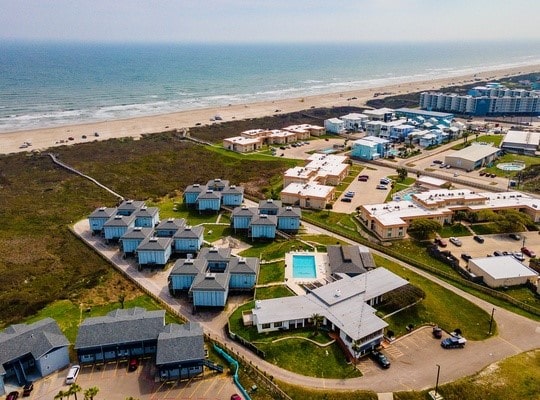 birds eye view of property with a beach view and a water view