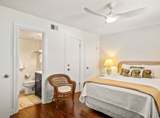 bedroom with dark wood-type flooring, connected bathroom, and ceiling fan