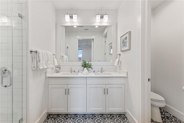 full bathroom with double vanity, a stall shower, toilet, and a sink