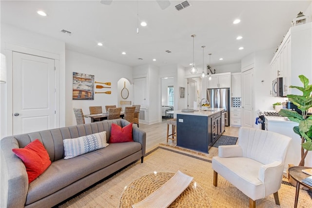 living area with visible vents, recessed lighting, and light wood-style floors