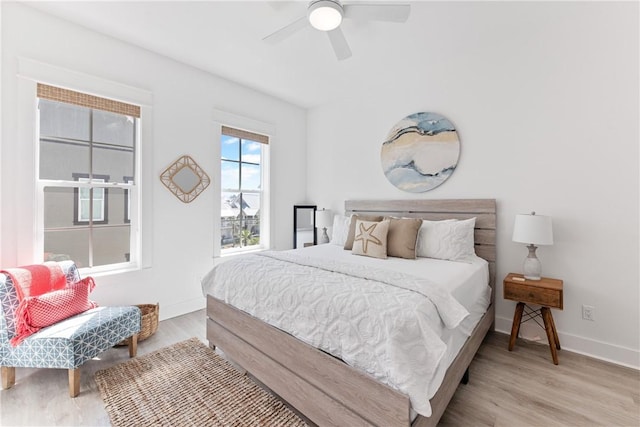 bedroom with ceiling fan, baseboards, and wood finished floors