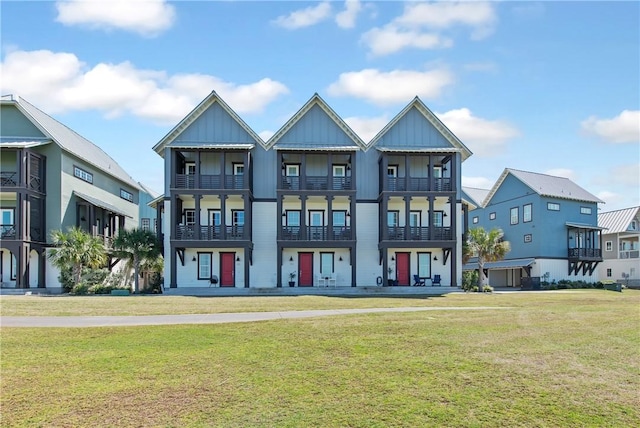 townhome / multi-family property with a front yard and board and batten siding