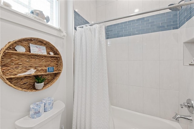 bathroom featuring shower / bath combination with curtain and toilet